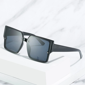 Fashionable oversized square sunglasses with black frame and rivets on stone pedestal