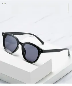Classic black cat-eye sunglasses with silver dot details on a white marble display