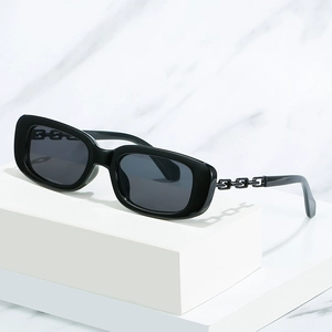 Lunettes de soleil carrées noires rétro avec branches en chaîne sur fond marbre