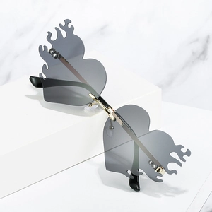 Randlose Sonnenbrille in Flammenform mit goldenem Metallrahmen auf Marmor-Hintergrund