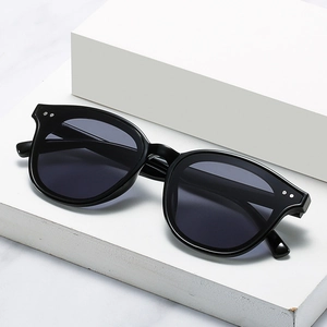 Fashionable cat eye sunglasses with black frame and dark grey lenses on white background