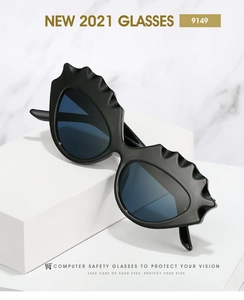 Détail de lunettes de soleil œil de chat noires à bords ondulés sur fond de marbre