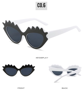 Vue détaillée des lunettes de soleil œil-de-chat bicolores noir et blanc avec accents ondulés