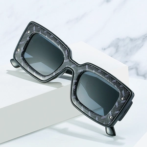Moderne quadratische Sonnenbrille mit geometrischem Muster und silbernen Nieten