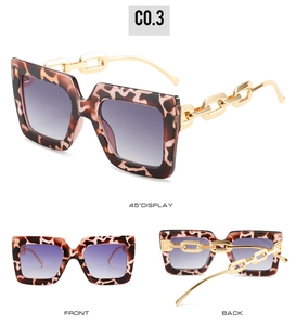 Detail of square leopard print sunglasses featuring bold gold chain temples and gradient lenses