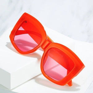 Modern oversized square sunglasses with bright orange frames and purple gradient lenses