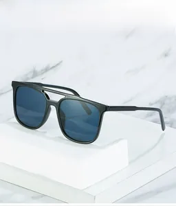 Close-up of stylish black square double-bridge sunglasses on a white marble platform