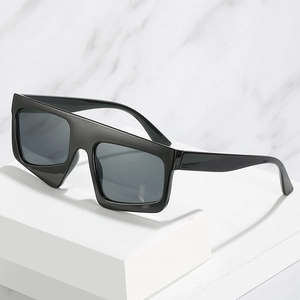 Quadratische Oversize-Sonnenbrille mit schwarzem Rahmen und grauen Gläsern auf Marmor