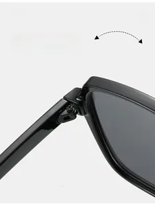 Close-up of a durable metal hinge on black oversized sunglasses with secure screw detail