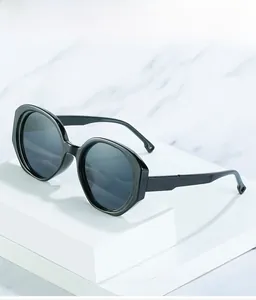 Detail of black geometric oval sunglasses with unique circular cutouts on the temple tips