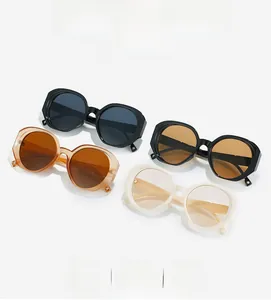 Close-up of stylish oval sunglasses in black, brown, amber, and cream thick frames