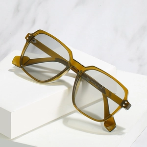 Olive green semi-transparent oversized square sunglasses with light gray lenses on stand