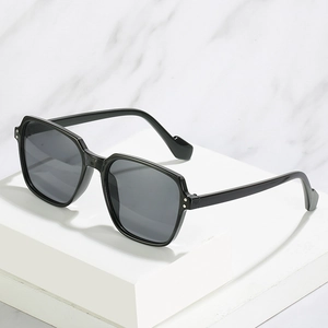 Modern oversized square sunglasses with black frame and metal rivet detail on white platform