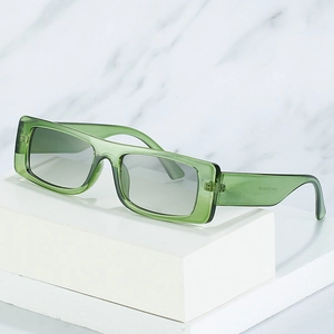 Retro rectangle sunglasses with transparent green frames and light gray lenses on a pedestal