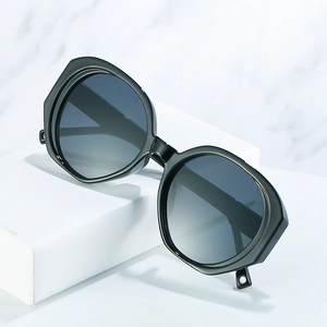 Fashionable oversized black oval sunglasses with gradient grey lenses on marble background