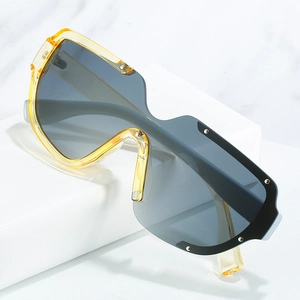Lunettes de soleil oversize jaunes tendance avec rivets en métal et verres gris sur marbre