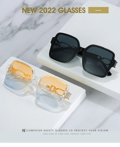 Close-up of square frames with gold chain temples on marble for computer safety