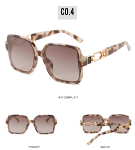 Detail view of tortoiseshell square sunglasses featuring gold metal chain temples and brown lenses