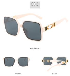 Detail view of cream square sunglasses featuring elegant gold chain temple design