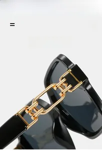 Detail of premium golden metal chain hinge on retro square black sunglasses