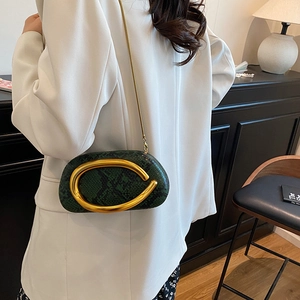 Close-up of dark green snake pattern bag with gold ring hardware and chain strap