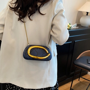 Detail of blue snake print bag featuring a gold statement buckle and chain strap