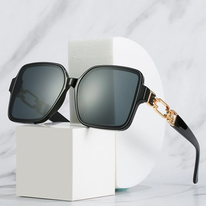 Retro square oversized sunglasses with black frames and gold chain detail on temple