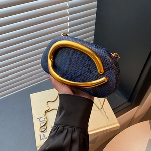 Detailed close-up of navy snakeskin pattern and signature gold abstract metal handle