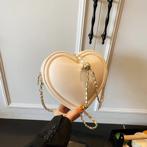 Minimalist beige heart shaped crossbody bag with elegant gold chain strap and metal ball