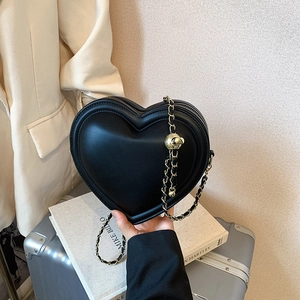 Chic black heart-shaped crossbody bag with gold chain strap and floral accent