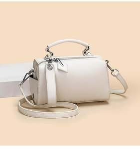 Détail du sac Boston crème montrant la texture du cuir grainé et la poche latérale pratique