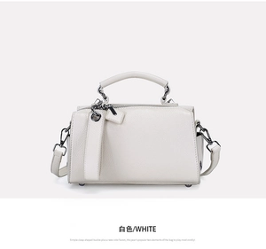Vue détaillée du sac Boston blanc montrant la texture cuir grainé et boucles argentées