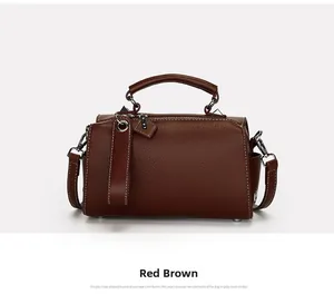 Vue détaillée du sac Boston en cuir marron rougeâtre avec motif litchi et bandoulière