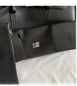 Detail of black lychee grain leather handbag featuring silver twist lock and side zipper