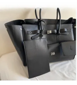 Macro detail of black tote bag featuring classic strap buckle and small hanging pouch