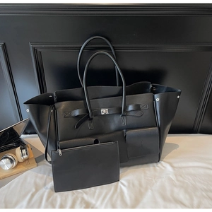 Detail of black leather tote bag with silver metal turn-lock and matching pouch