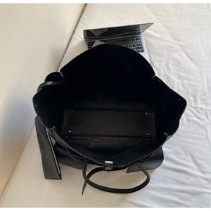 Interior view showing large capacity black tote bag with laptop and inner pouch