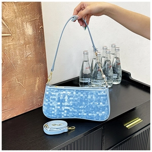 Détail du sac baguette bleu clair à texture tissée avec bandoulière réglable