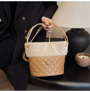 Detail of quilted leather bucket bag with plush white fur trim and elegant buckle