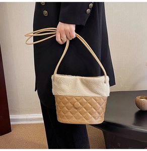 Detail of plush faux fur bucket bag with quilted faux leather base and slim handles