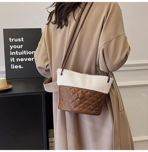 Detail of vintage quilted leather bucket bag with white plush trim on beige trench coat