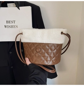 Detail of plush faux fur and quilted brown leather contrast on a stylish bucket bag