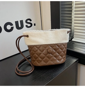 Detail of contrasting faux fur and brown quilted leather on the bucket bag