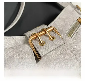 Detailed close-up of high-quality gold hardware and zipper on denim monogram bag