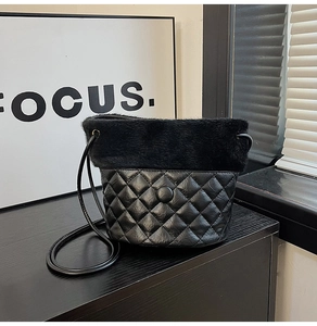 Detail of plush faux fur and quilted rhombus pattern on a black bucket shoulder bag