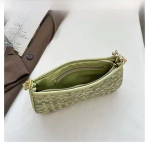 Vue détaillée de l'intérieur du sac tissé vert avec perle et fermeture dorée