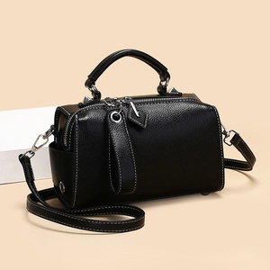 Sac Boston minimaliste en cuir noir avec surpiqûres blanches et finitions argentées