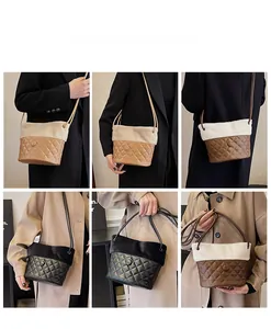 Detail view of plush quilted bucket bag with leather stitching and long shoulder strap