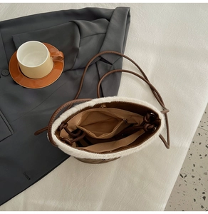 Detailed interior of vintage bucket bag with zip pocket and white plush trim