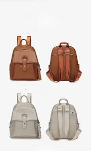 Detail view of khaki and orange lychee pattern backpacks with metal ring buckle and straps